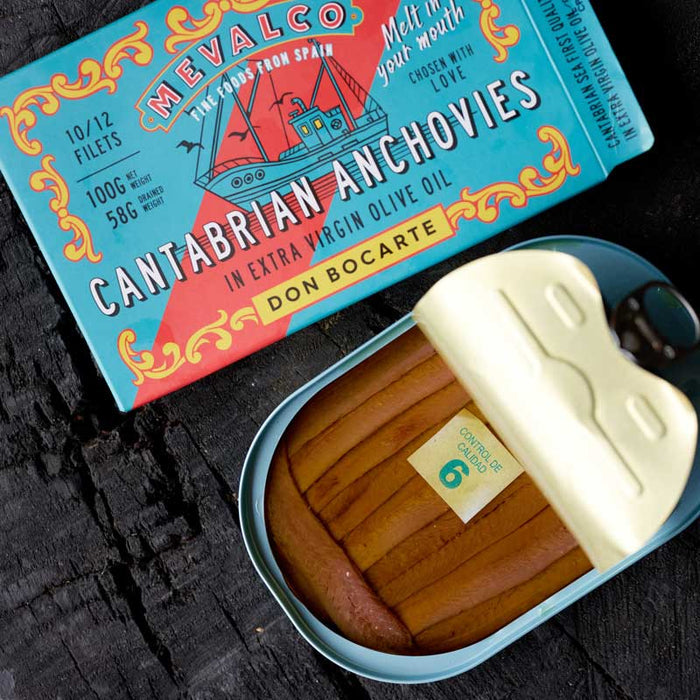 An open can of Mevalco Don Bocarte Cantabrian Anchovies with decorative label on a dark background