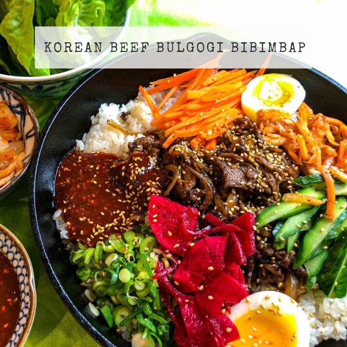 Recipe for Korean Beef Bulgogi Bibimbap showing a rice bowl with beef, egg, cucumber, pickled beetroot and ssamjang sauce.