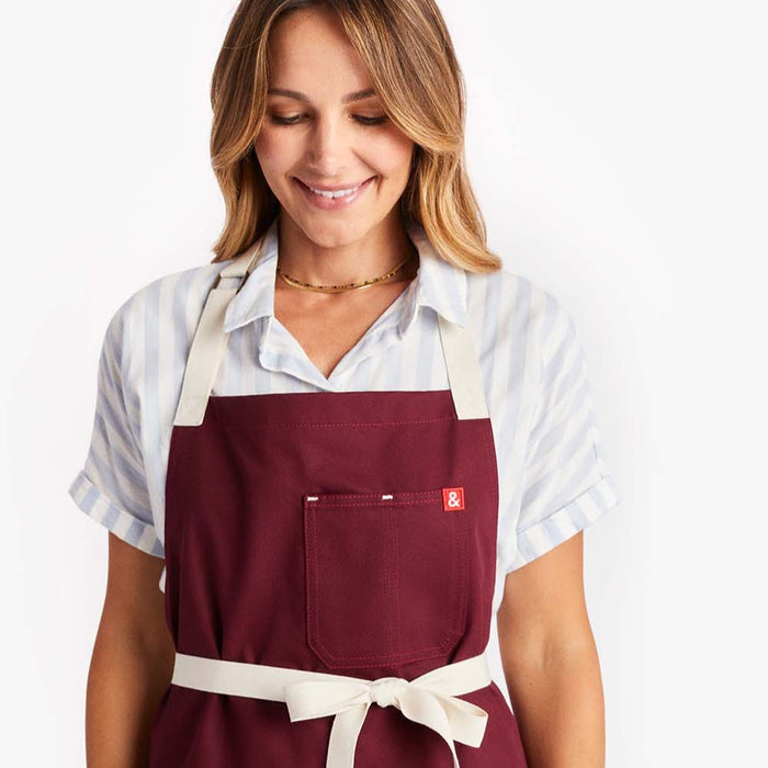 Young woman wearing Hedley & Bennett Bordeaux Crossback Apron tied in front