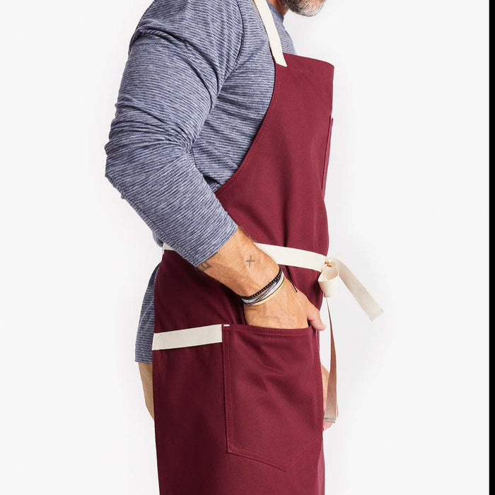 Man using large front apron pockets on Bordeaux Crossback Apron