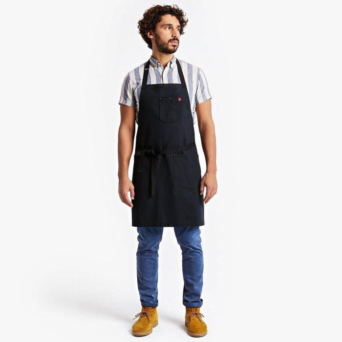 Young man wearing apron with blue jeans and work boots