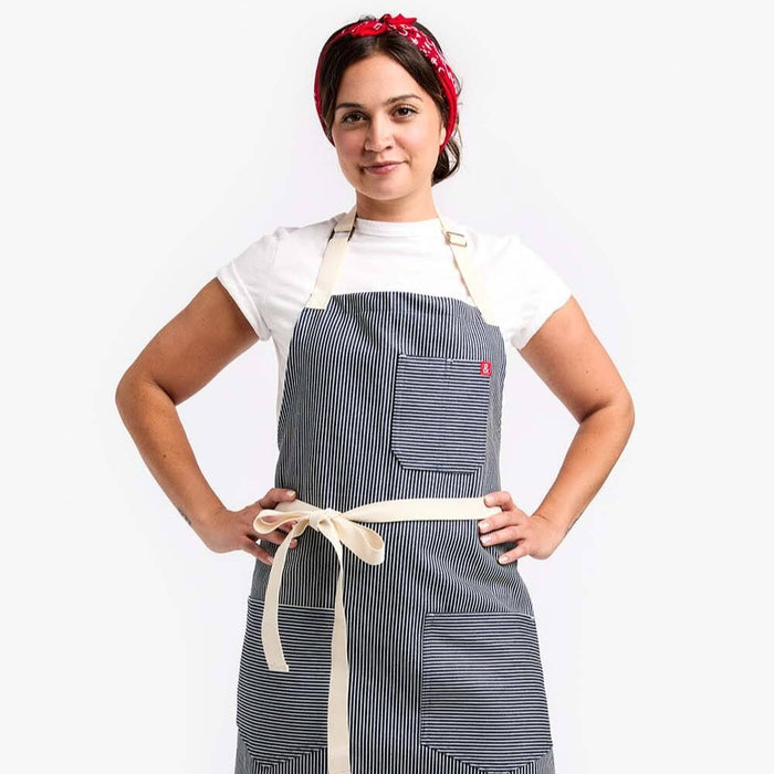 Woman with a red bow in her hair wearing a Hickory apron.