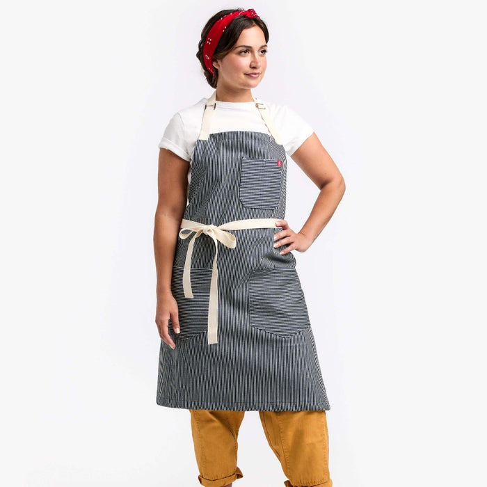 Young woman wearing work boots and a striped apron