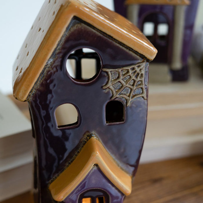 Close up of medium-sized ceramic halloween building with cobweb detail.