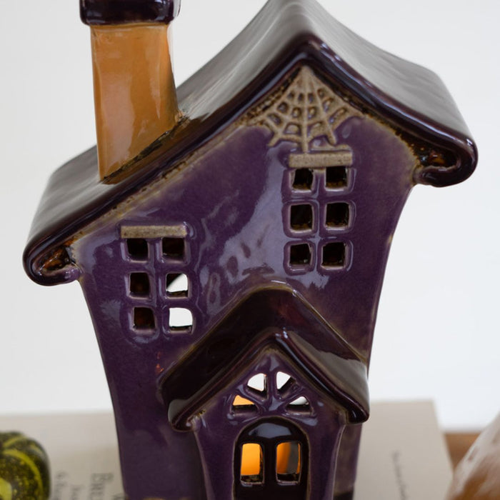 Close up of large ceramic halloween building with cobweb detail.