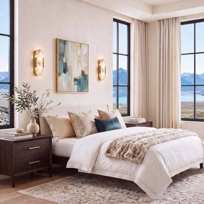 Pair of glowing oval Spanish natural alabaster wall sconces mounted on white wall flanking art painting in bright master bedroom