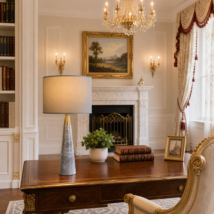 Illuminated grey marble table lamp on dark executive wooden desk in luxury classical study
