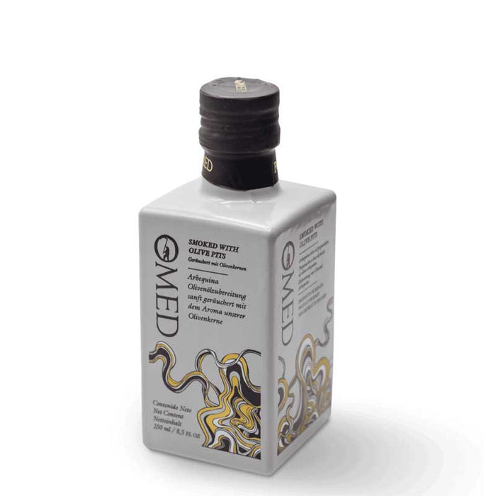 A square grey glass bottle of O-Med Smoked Arbequina Extra Virgin Olive Oil with a black cap, featuring a label with black text and gold and black smoke illustrations, set against a plain white background.