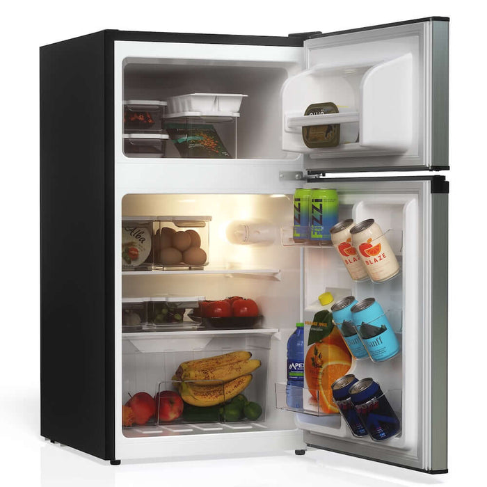 TCL 18 in. 3.1 Cu. Ft. Compact Top Freezer Mini Fridge in Silver (TRM31D4AV) with open door showing food and drinks inside on a white background