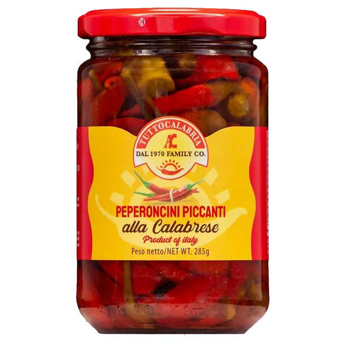 A glass jar of Tutto Calabria Whole Sun Dried Chilli Pepper preserved in oil with red and yellow branding, pictured on a white background