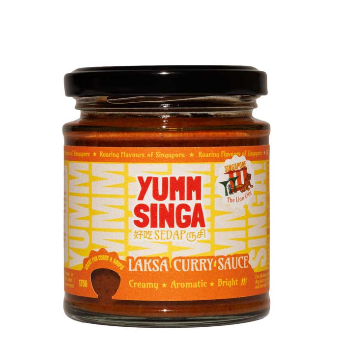 A jar of Yumm Singa Laksa Curry Sauce with a bright orange label and red branding on a white background
